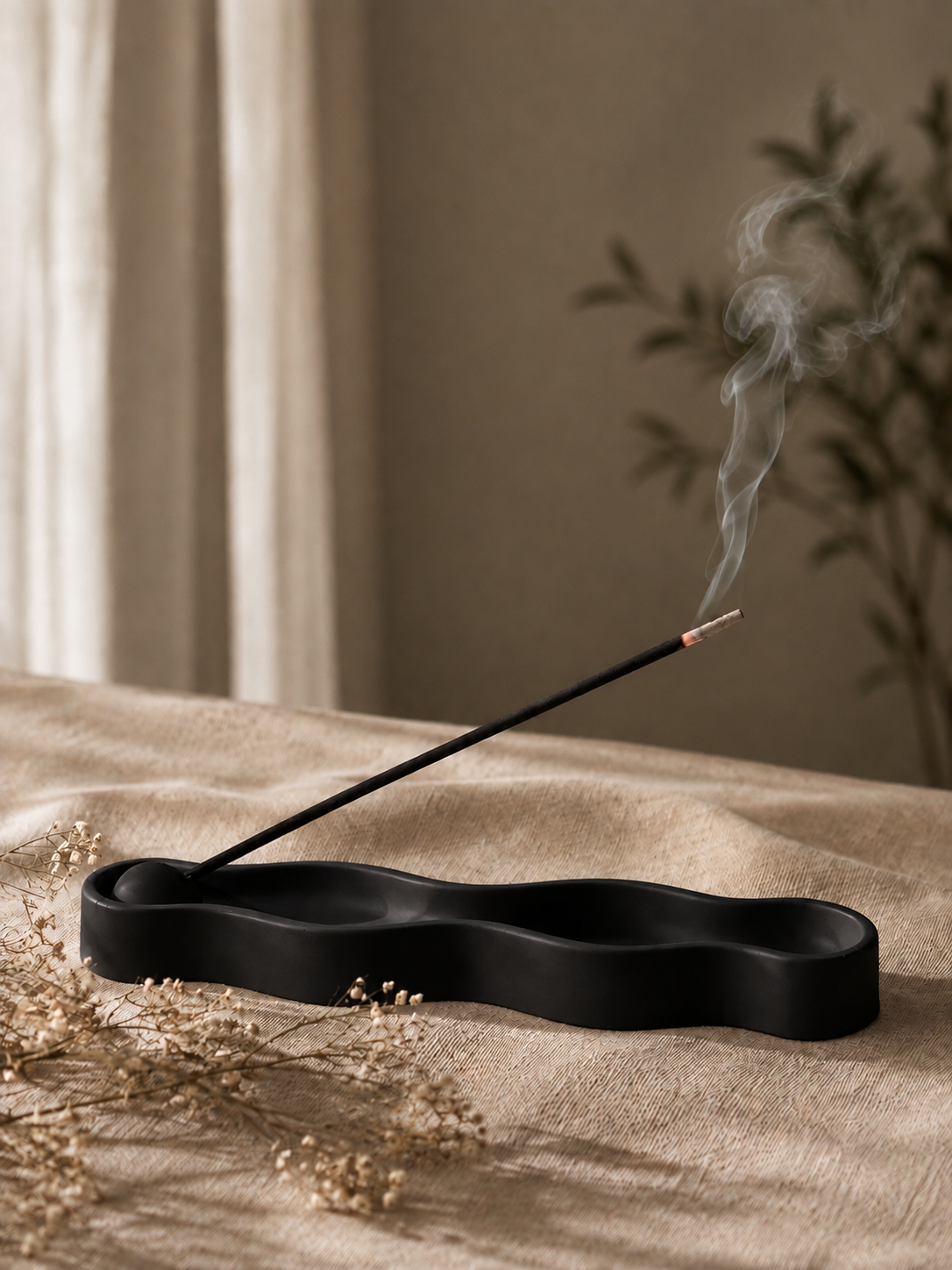 Ripple Incense Holder in black with lit incense stick