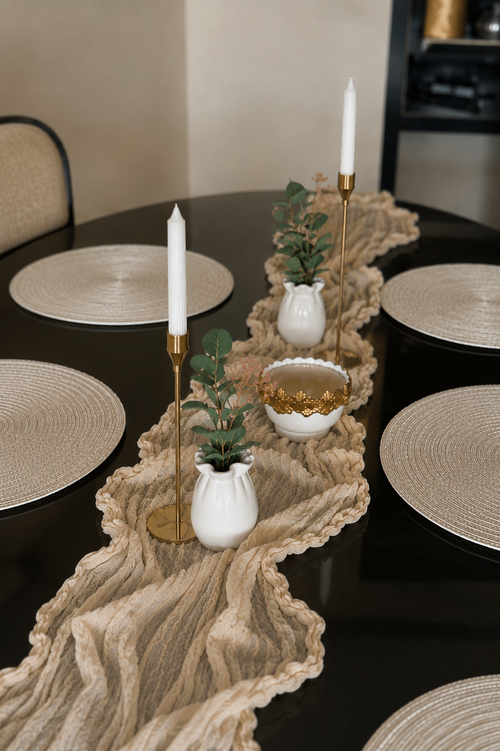 Linen Wave table set styled with gold candleholders and white vases on dark table