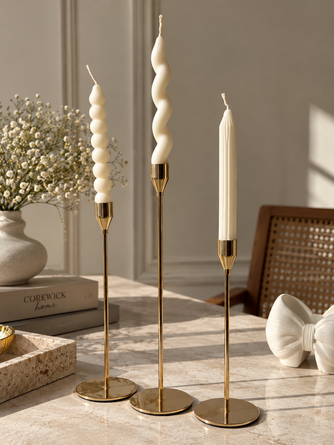 Gold candlestick set with mixed bubble, spiral and classic taper candles on marble surface