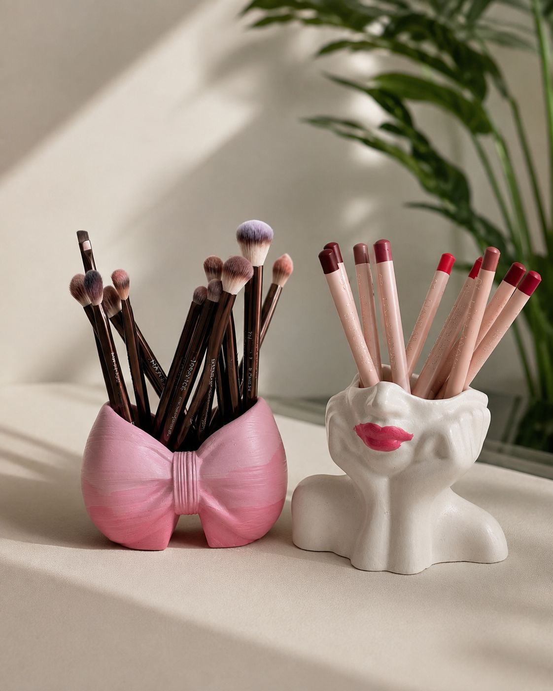 The Rosy Duo — pink bow brush holder and white lady face brush holder side by side