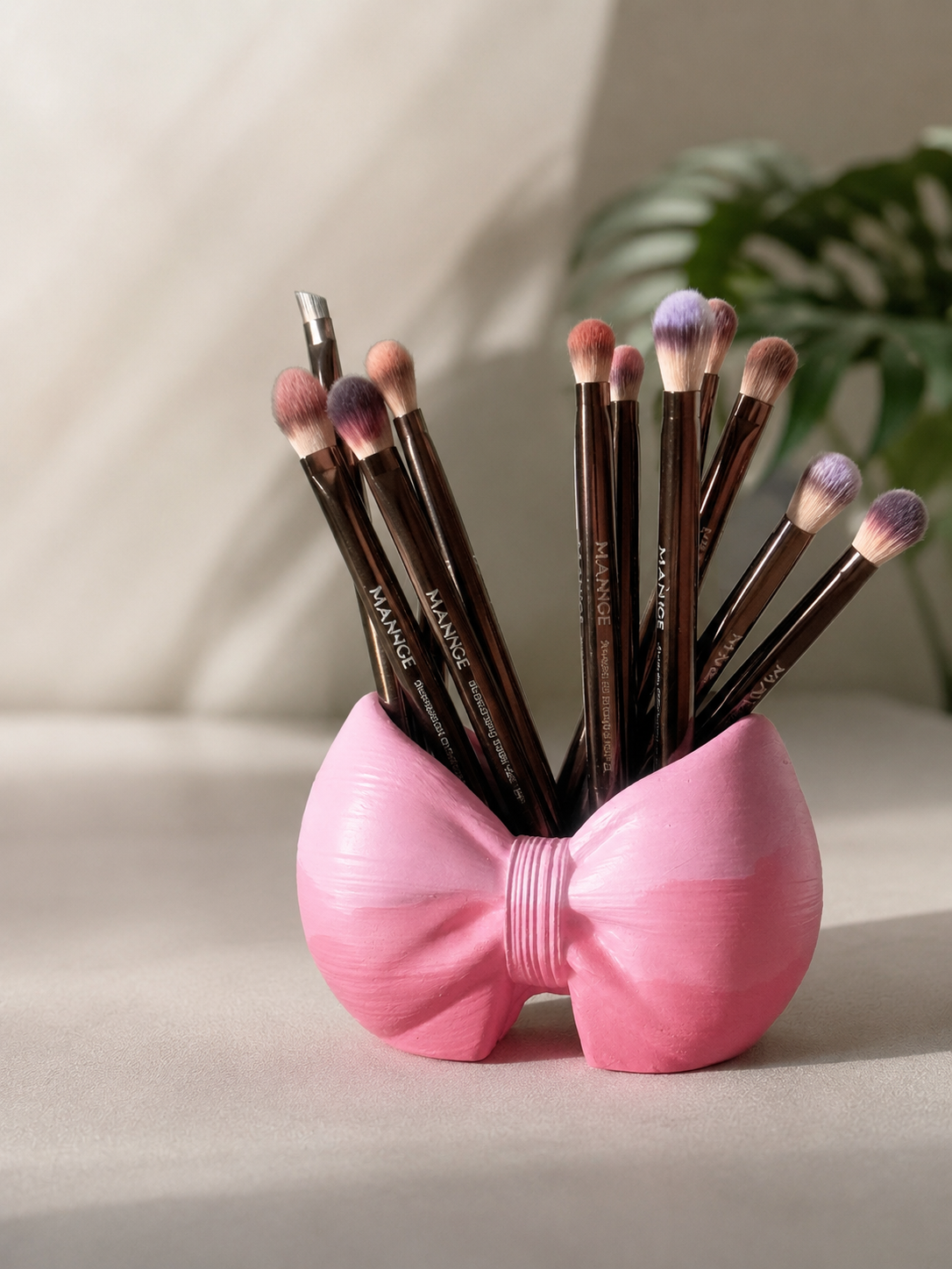 Rosy Bow Brush Holder in pink holding makeup brushes