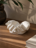 The Giving Hands cupped sculpture on wooden surface
